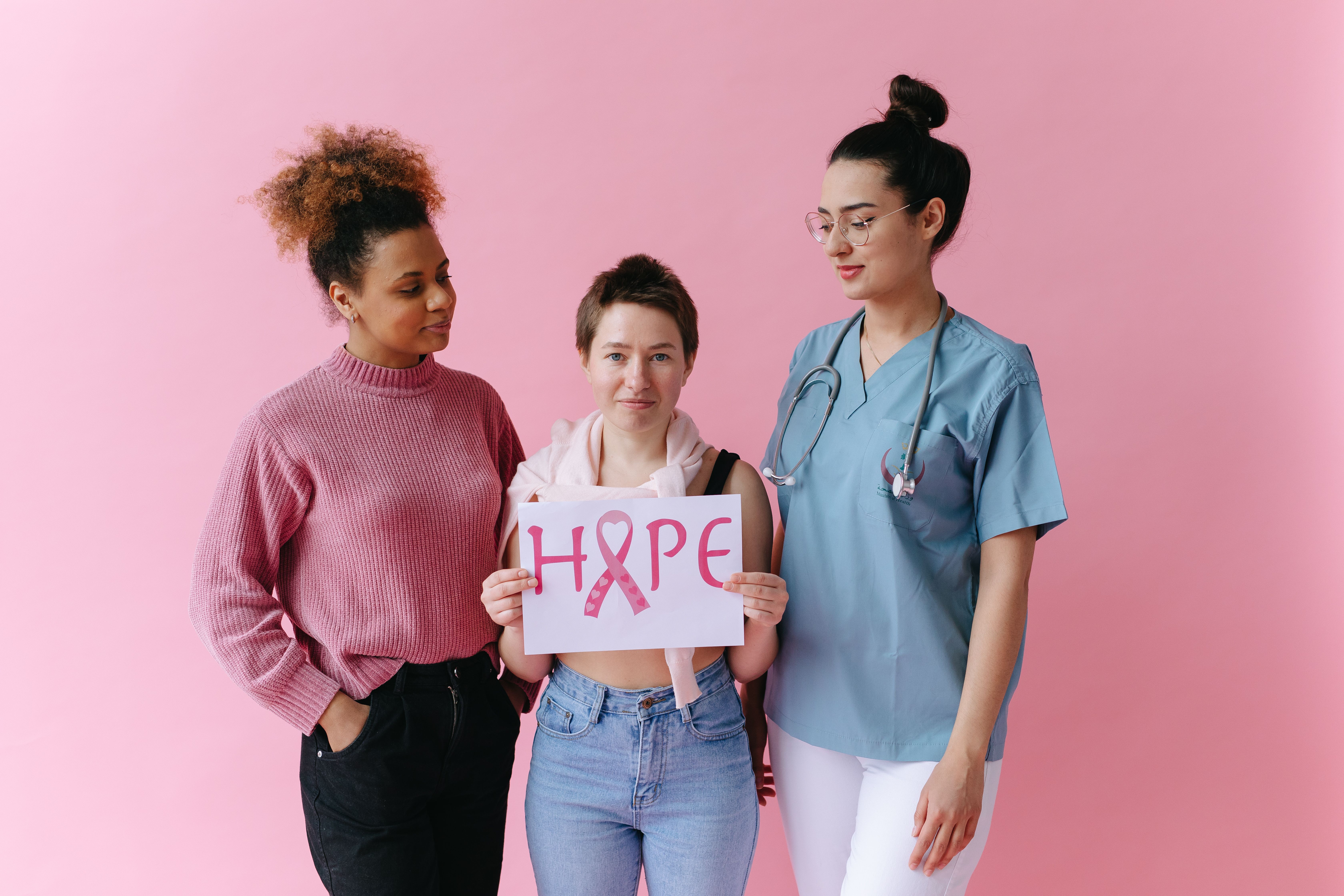 Women standing together holding a hope sign with a pink ribbon
